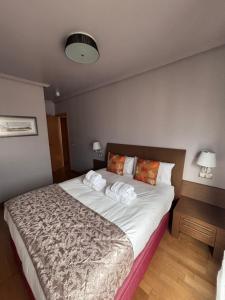 a bedroom with a large bed with towels on it at Apartamento Oviedo Naranco in Oviedo