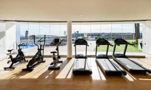a gym with several treadmills and a large window at Infinity View apartment in Arenales del Sol
