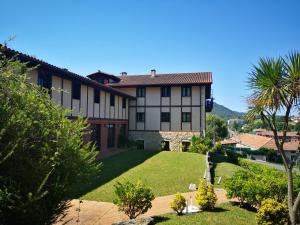 a view of a house with a yard at Hotel Ibaigune in Murueta