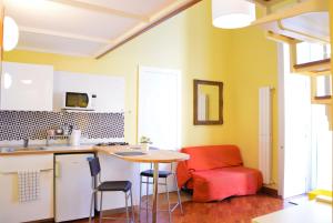 a kitchen with a table and a red chair at 1878 Sorrento Guest House in Sorrento
