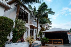 a house with palm trees in front of it at Kaze Consolidate Home Inn in Kigali