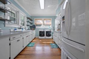 a kitchen with white appliances and wooden floors at The Anchor Once Upon A Tide Villas POOL in Bay Saint Louis
