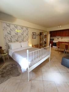 a bedroom with a white bed and a kitchen at Nafplio Nook 2 in Nafplio