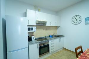 a kitchen with white appliances and a clock on the wall at Edificio Prieto Vivienda 2D in Puerto del Rosario +30 photos