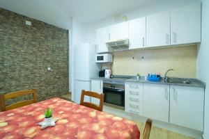 a kitchen with a table and a kitchen with white cabinets at Edificio Prieto Vivienda 2D in Puerto del Rosario