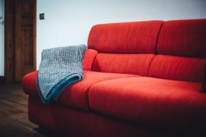 a red couch with a blue blanket on it at Maison Carrel Elegant 8 in Breuil-Cervinia