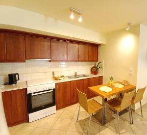 a kitchen with wooden cabinets and a table with chairs at Nafplio Nook 2 in Nafplio
