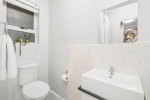 a white bathroom with a toilet and a sink at The Orion 16 in Table View +15 photos