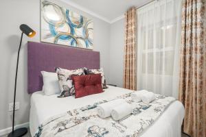 a bedroom with a large white bed with colorful pillows at The Orion 16 in Table View