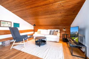 a living room with a white couch and a television at Ferienwohnung Dorfmitte in Reit im Winkl