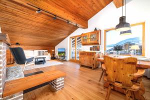a living room with a wooden ceiling and a dining room at Ferienwohnung Dorfmitte in Reit im Winkl