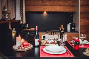 a table with a plate of food and two bottles of wine at Maison Carrel Elegant 8 in Breuil-Cervinia +35 photos