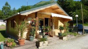a small house with potted plants on a deck at ZEcamping 3 chiens acceptés hammam piscine chauffée in Louvie-Juzon +6 photos