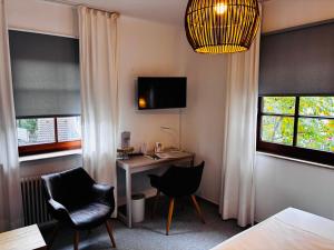 a room with a desk and a chair and a bed at Hotel-Restaurant & Metzgerei Rößle in Dettingen an der Erms
