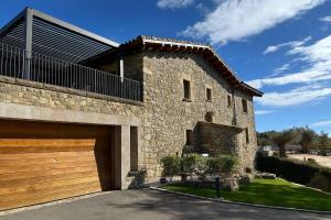 a large stone house with a garage at Villa Mas Summit in Collsuspina