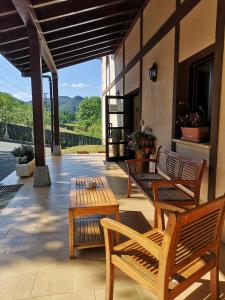 a patio with two wooden benches and a table at Hotel Ibaigune in Murueta
