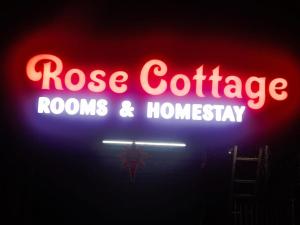 a neon sign that says rose cottage rooms and homogeneity at Rose Cottage in Devikolam