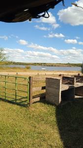 a fence next to a field with a body of water at Apartamento La Balsa in San Gregorio de Polanco +3 photos