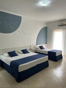 two beds in a bedroom with blue and white at Hotel do Feijão in Cachoeira Paulista +56 photos
