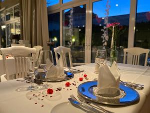 a table with plates and glasses and flowers on it at Hotel-Restaurant & Metzgerei Rößle in Dettingen an der Erms