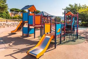 a playground with a slide in a park at Appartement Premium Genius - Chambre séparée -vue Mer -Jardin Clôturé -Terrasse -Parking - Piscine Chauffée du 04 Avril au 01 Novembre- Saint Raphaël in Agay - Saint Raphael