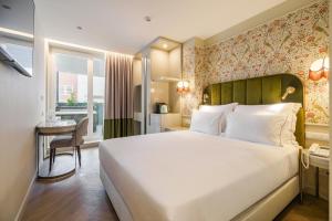 a hotel room with a large bed and a desk at Olympia Lis Baixa Hotel in Lisbon