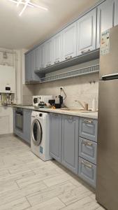 a kitchen with a washing machine and a refrigerator at Ultracentral Piata in Caracal