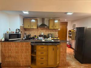 a kitchen with wooden cabinets and a black refrigerator at باليمرا in Ain Sokhna