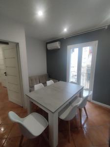 ein Esszimmer mit einem Tisch und weißen Stühlen in der Unterkunft Mumin in Carini + 20 Fotos