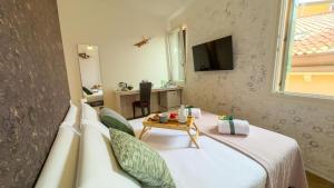 a bedroom with a bed with a tv and a table at Cà De La Corona EXPERIENCE in Chioggia