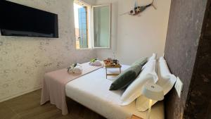 a bedroom with a bed with a television on the wall at Cà De La Corona EXPERIENCE in Chioggia
