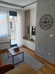 a living room with a clock on the wall and a table at Aria lux Titova vila in Zlatibor +19 photos