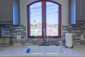 a sink in a kitchen with a window at The Little Pumpkin Guest House in San Diego +43 photos