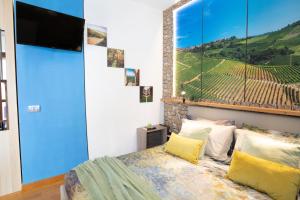 a bedroom with a bed with a large painting on the wall at Appartamento Alba centro storico in Alba