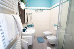 a white bathroom with a sink and a toilet at Appartamento Alba centro storico in Alba +10 photos