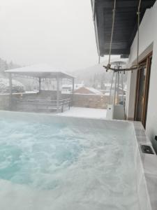a bath tub filled with water in a room at Wellness Chalet Apartment Hochkalter in Bischofswiesen +4 photos
