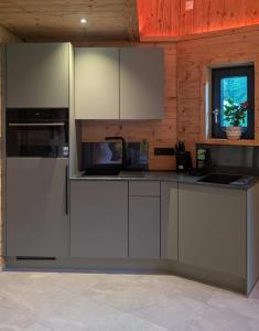 a kitchen with white cabinets and a counter top at Wellness Chalet Apartment Hochkalter in Bischofswiesen