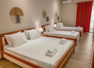 zwei Betten in einem Zimmer mit zwei Betten sidx sidx sidx in der Unterkunft Kleanthi`s Hotel in Himarë