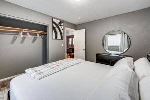 a bedroom with a large white bed and a mirror at Easily Explore Anchorage! Modern Duplex Near Town in Alaska Regional Hospital Heliport