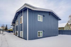 a blue house in the snow at Easily Explore Anchorage! Modern Duplex Near Town in Alaska Regional Hospital Heliport