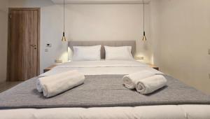 a bedroom with a large bed with towels on it at Panorama Serenity Suites in Thessaloniki
