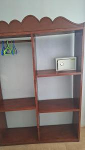 a book shelf with a clock and a radio at Green Oasis in Nungwi
