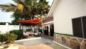 a patio with an orange umbrella on a house at Green Oasis in Nungwi