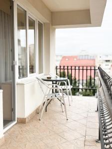a patio with chairs and a table on a balcony at Vila Roma in Deva