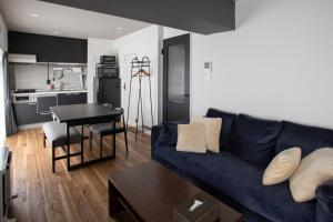 a living room with a blue couch and a kitchen at NIYS apartments 56type in Tokyo
