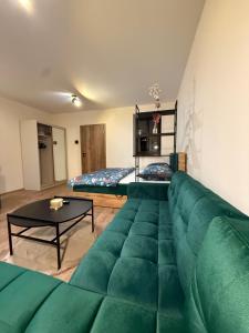 a large green couch in a room with a bed at Apartmán Mia 1 in Liptovský Mikuláš
