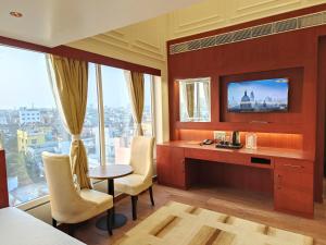 a hotel room with a desk and a window at Hotel Central Tree in Muzaffarpur