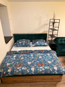 a bedroom with a bed with a blue comforter at Apartmán Mia 1 in Liptovský Mikuláš +14 photos