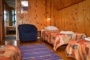 a room with two beds and a chair in it at Jöekalda Accommodation in Pulli