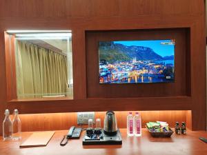 a television on a wall above a table with a coffee maker at Hotel Central Tree in Muzaffarpur